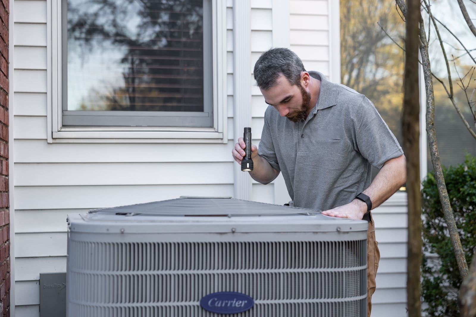 Technician servicing an outdoor air conditioner