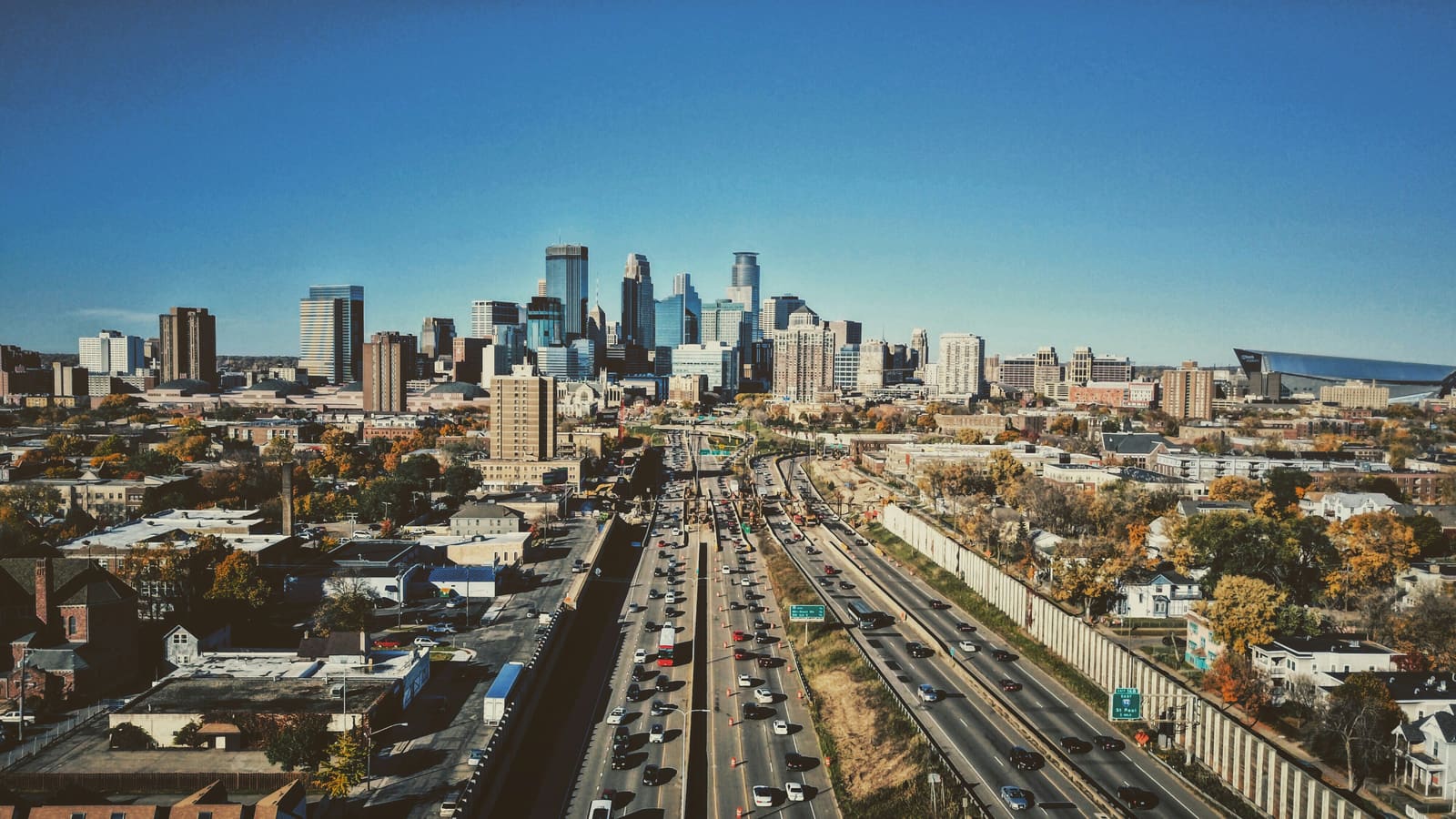 Aerial view of the downtown Minneapolis skyline with a busy freeway leading toward it